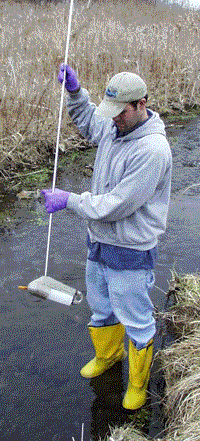 WEP staff technician samples water from a tributary to Onondaga Lake